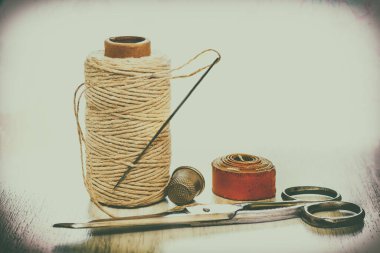 Beyaz arka planda el yapımı dikiş aksesuarları, terzi bandı, iplik makarası, makas, yüksük. Dikiş seti. Retro tarzı. Metnin için yer