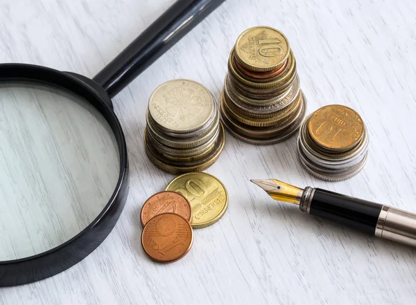 Penna, mynt och förstoringsglas — Stockfoto