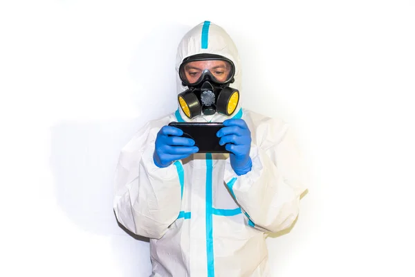 doctor in safety suit on white background. protection against coronavirus. movil phone.