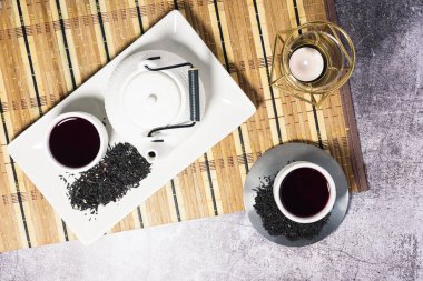 Japon masa örtüsüne mum konmuş beyaz çay seti.