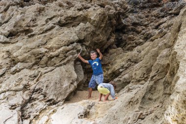 Sahilde gün batımında oynayan iki beyaz çocuk.