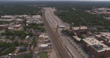Atlanta Havalimanı v550 Pamuk değirmeni çatı katları yakınlarındaki tren raylarını takip ediyor, birden fazla mahalle manzarası olan alçak ile ters yönde - Ağustos 2019