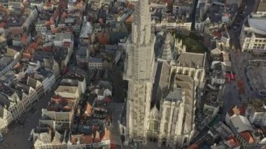 Antwerp Belçika Hava aracı V33 Birdeye, gün batımında şehir manzarası ile şehir merkezindeki Leydi Antwerp Katedrali 'nin etrafında uçuyor.