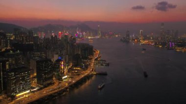Hong Kong Havacılık v11, Kowloon Körfezi üzerinde alacakaranlıkta geriye doğru uçuyor.