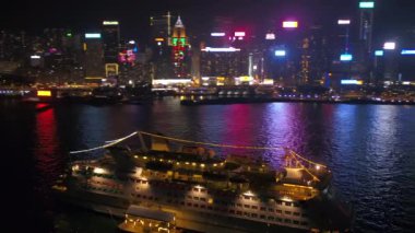 Hong Kong Havacılık v28 Victoria Limanı üzerinde alçaktan uçuyor gece şehir manzaralı küçük bir yolcu gemisinin etrafında - Şubat 2017