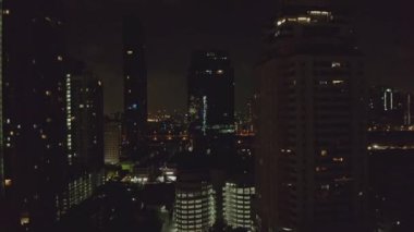 Bangkok Tayland Havacılık v167 Watthana ve Soi Sukhumvit bölgelerindeki gökdelenler arasında alçaktan uçuyor.