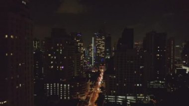 Bangkok Tayland Havacılık v168 Watthana ve Soi Sukhumvit bölgelerindeki gökdelenler arasında alçaktan uçuyor.