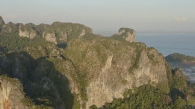 Krabi Tayland Havayolları V6 Railay Sahili ve kireçtaşı uçurumları etrafında uçuyor köy manzaralı ve günbatımında tatil köyleri - Ocak 2020