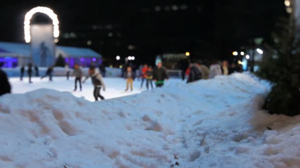 Gente patinando sobre hielo por la noche — Vídeos de Stock