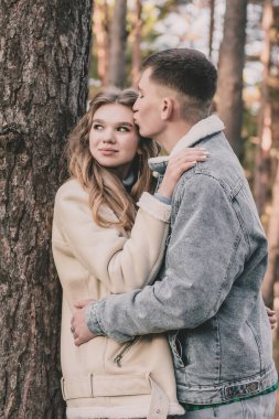 Adam kızı ağaca yasladı. Çam ormanında onu kucakladı ve öptü.