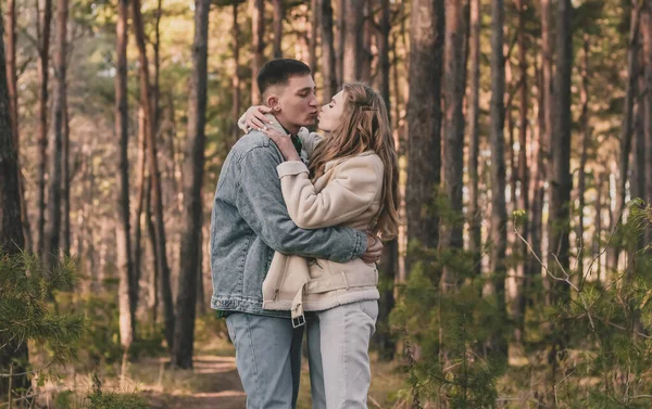 Chico Abraza Chica Firmemente Besa Mientras Está Bosque Pinos — Foto de Stock