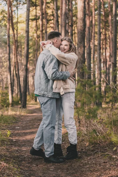 Killen Kramar Flickan Hårt Och Kysser Henne Kinden Medan Tallskogen — Stockfoto