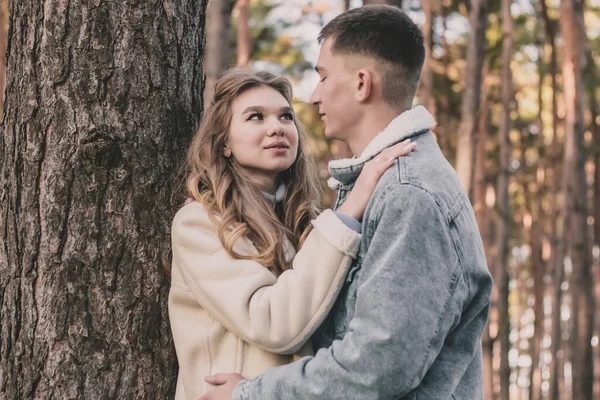 Adam kızı ağaca yasladı ve çam ormanındayken ona sarıldı.