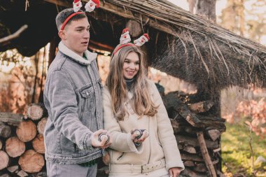 Kafalarına yeni yıl halkaları takmış bir çift yapay kar üflüyor.