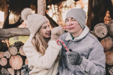 Bir çift odunların arkasına oturur, yüzlerine şeker tutar ve suratlarını buruşturur.