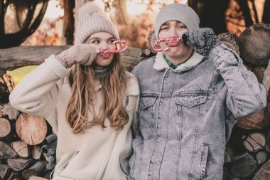 Bir çift odunların arkasına oturur, yüzlerine şeker tutar ve suratlarını buruşturur.