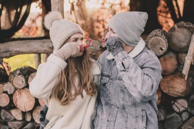Bir çift odunların arkasına oturur, yüzlerine şeker tutar ve suratlarını buruşturur.