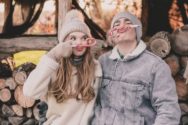 Bir çift odunların arkasına oturur, yüzlerine şeker tutar ve suratlarını buruşturur.