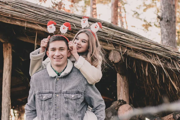 新年の訪れの美しいカップルは薪で作られたガゼボの背景に笑顔 — ストック写真