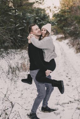 Çiftler kışın ormanda oynaşırlar.