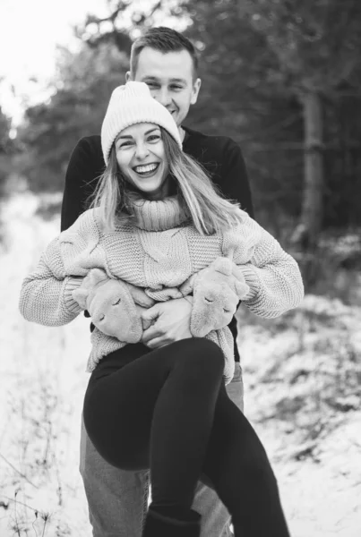 男は雪の森の黒と白の写真を背景に腕の中で女性を円 — ストック写真