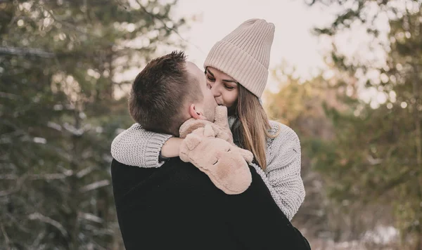 Woman Dressed Mittens Hugs Man Face Kisses Background Snowy Forest — Stock Photo, Image