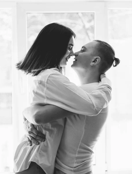man hugging woman black and white photo