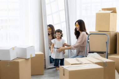 Anne ve kızı yeni bir eve taşınıyor. Paket karton göndererek yeni mobilya al. Mutlu bir an anne ve çocuk sabah.