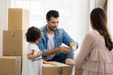 Aile yeni mobilya aldı ve evin düzenlenmesine yardım etti. Babam ve kızım eve yeni taşınıyorlar. Paketleri açıyorlar ve oturma odasının zeminini düzenliyorlar..