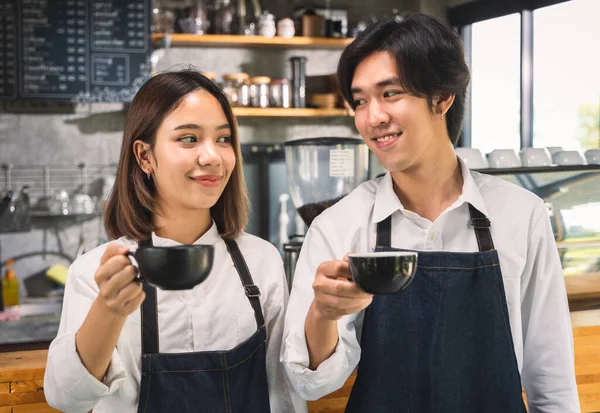コーヒーショップカフェでホットコーヒーラテを作っている2人のアジアのコーヒーウエートレス 店内のコーヒーマシンで働くバリスタ — ストック写真