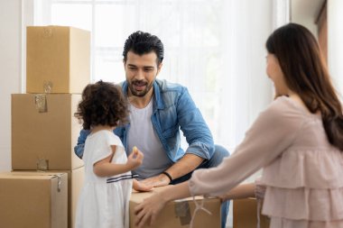 Aile yeni mobilya aldı ve evin düzenlenmesine yardım etti. Babam ve kızım eve yeni taşınıyorlar. Paketleri açıyorlar ve oturma odasının zeminini düzenliyorlar..