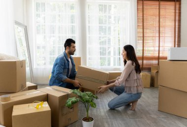 Aile yeni mobilya aldı ve evin düzenlenmesine yardım etti. Karı koca eve yeni taşınıyor. Paketleri açıyorlar ve oturma odasının zeminini düzenliyorlar..