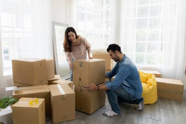 Aile yeni mobilya aldı ve evin düzenlenmesine yardım etti. Karı koca eve yeni taşınıyor. Paketleri açıyorlar ve oturma odasının zeminini düzenliyorlar..