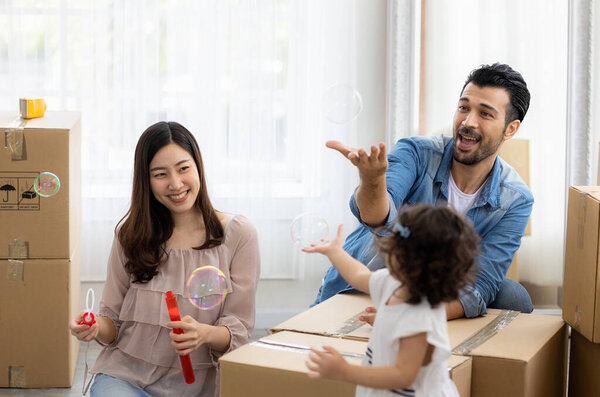 Happy time family blow soap bubbles relax in living room. Everyone having fun in the house.