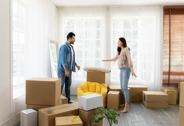 The family just bought new furniture and helped organize the house. Husband and wife just moving new home. They unpacking parcel box and arranging on the floor in the living room.