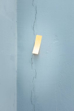 Çatlak betonu kapatın. Dış duvarda hasar var. Yaşlı, yaşlı, yıpranmış ya da deprem etkisi. Yapışkan bandı macun, dolgu macunu, eklem dolgusu ya da epoksi ile onarmak, onarmak ya da kazımak için işaretlemeye