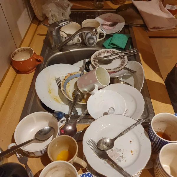 Dirty plates, cups and cutlery in a metal sink. — Stock Photo, Image