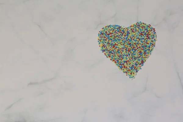 Saupoudrer disposées en forme de coeur sur un fond rustique en marbre gris blanc. Saint Valentin, carte de voeux. Arroseurs pour confiserie et pâtisserie, Espace pour copier, vue de dessus — Photo