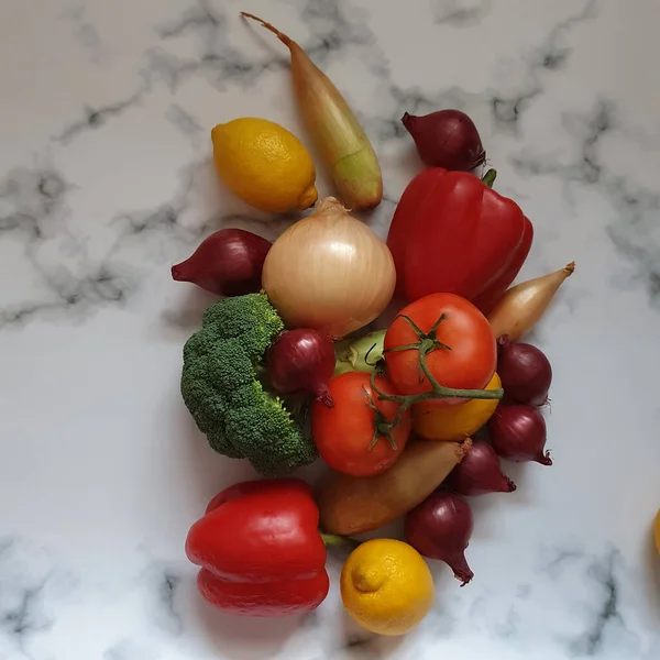 Verschiedenes Gemüse rote und gelbe Zwiebeln, Brokkoli, Tomaten, Paprika, Zitronen auf weißgrauem Marmor Hintergrund. Vitamine, gesunde Auswahl, Stärkung des Immunsystems, Antioxidantien, Lebensmittel, organische — Stockfoto
