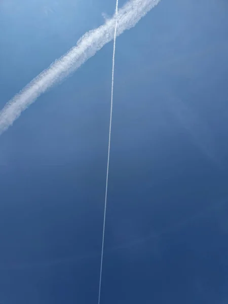 Два пересечения следов с самолетов в чистом голубом небе, скопировать пространство — стоковое фото
