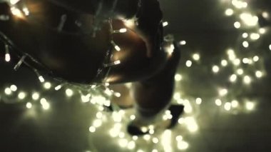 Kız ya da genç bir kadın bir Noel ağacını çelenkle süslüyor.