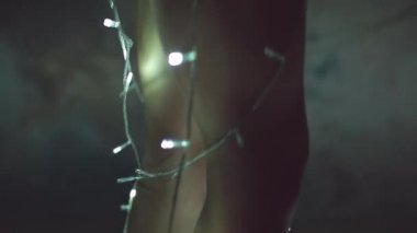 Kız ya da genç bir kadın bir Noel ağacını çelenkle süslüyor.