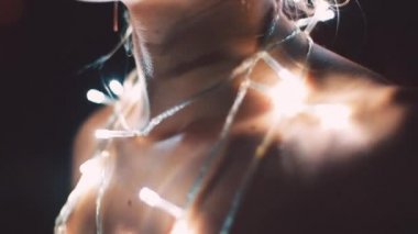 Kız ya da genç bir kadın bir Noel ağacını çelenkle süslüyor.