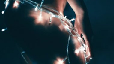 Kız ya da genç bir kadın bir Noel ağacını çelenkle süslüyor.