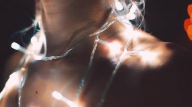 Kız ya da genç bir kadın bir Noel ağacını çelenkle süslüyor.