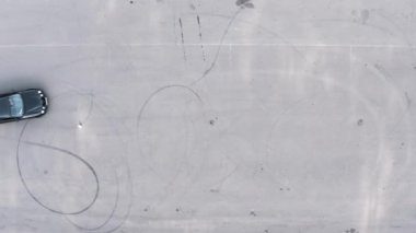 Siyah arabadaki öğrenci engelleri aşıyor. Lastikler arasında slalom. 