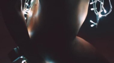 Kız ya da genç bir kadın bir Noel ağacını çelenkle süslüyor.