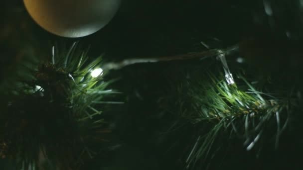 Chica o mujer joven decora un árbol de Navidad con una decoración de guirnalda — Vídeos de Stock
