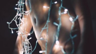 Kız ya da genç bir kadın bir Noel ağacını çelenkle süslüyor.