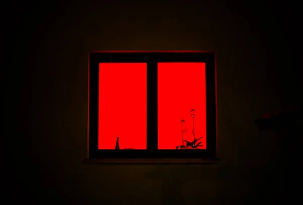 Camdan gelen kırmızı ışık. Kırmızı pencere geceleri mistik bir şekilde parlıyor.. 